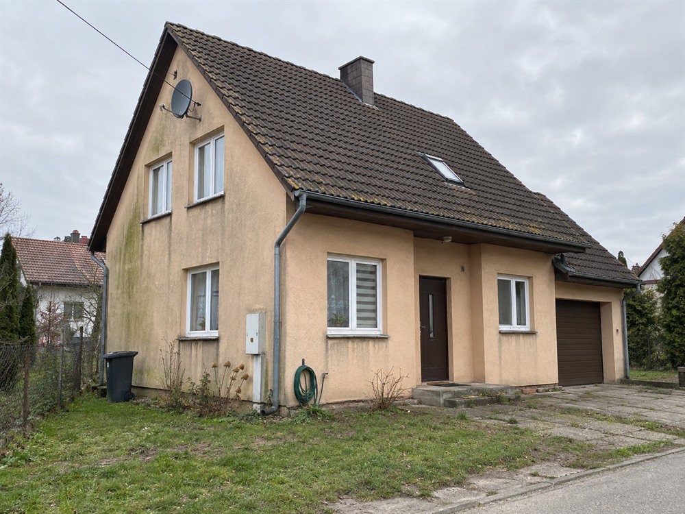Zdjęcie domu jednorodzinnego z wysłużoną beżową elewacją, przed zmianą